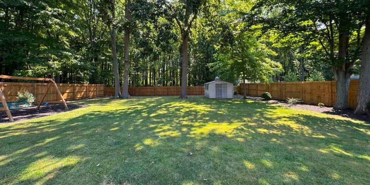 Freshly stained wood privacy fence around a Northeast Ohio backyard