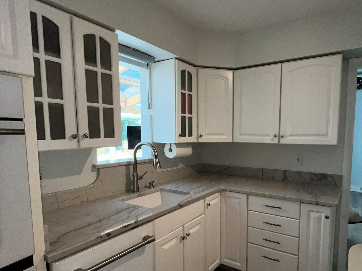 Remodeled kitchen with white cabinets and marble-look countertops in a Northeast Ohio home